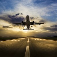 Passenger airplane taking off at sunset